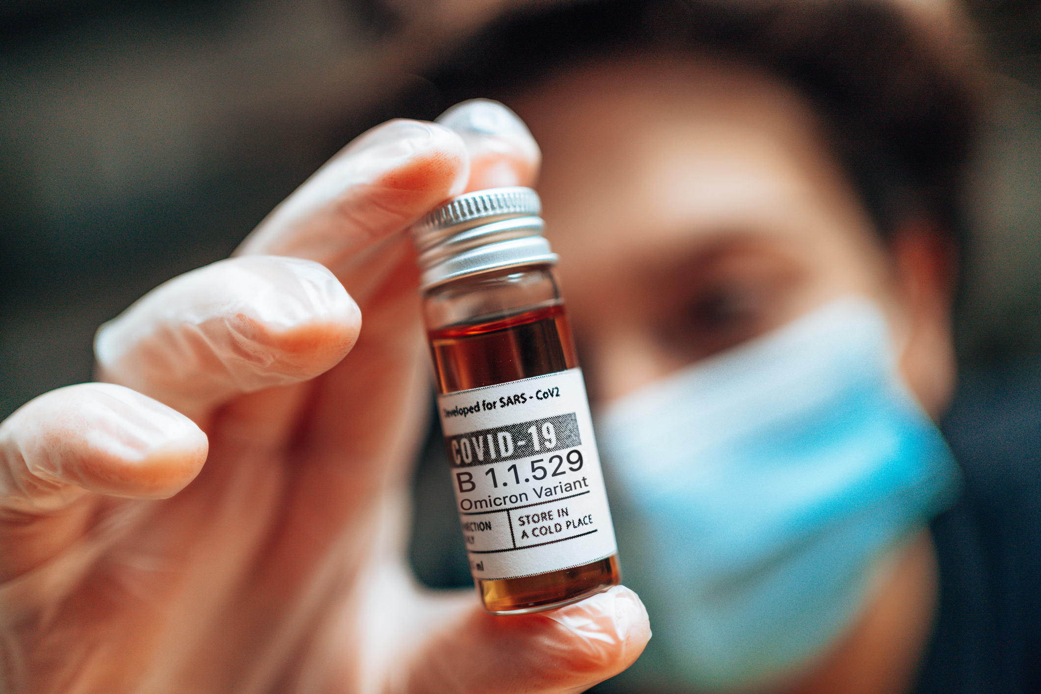 Nurse holding a bottle of COVID-19 booster vaccine.