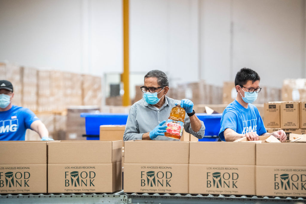 Volunteers sorting juice and other food items at a food bank.